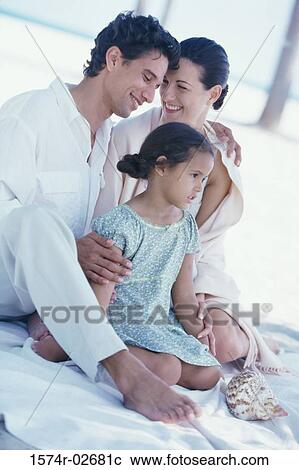 Parents sitting with their daughter on the beach View Large Photo Image Stock Image - Parents sitting with their daughter on the beach. Fotosearch