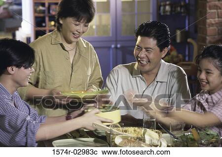 Stock Image - Parents with their children at a dining table. Fotosearch