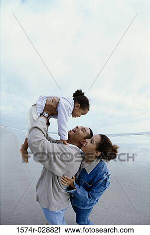 Parents with their daughter on the beach View Large Photo Image Stock Image - Parents with their daughter on the beach. Fotosearch