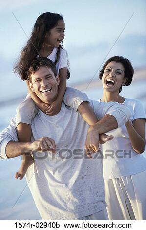 Stock Image - Parents with their daughter on the beach. Fotosearch