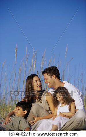 Stock Image - Parents with their son and daughter on the beach. Fotosearch