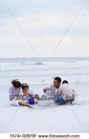 Stock Image - Parents with their son and daughter on the beach. Fotosearch