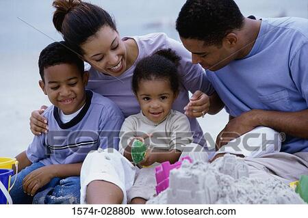 Stock Image - Parents with their son and daughter on the beach. Fotosearch