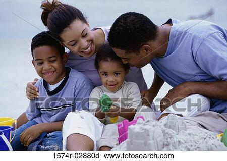 Stock Image - Parents with their son and daughter on the beach. Fotosearch