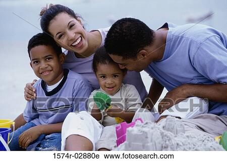 Stock Image - Parents with their son and daughter on the beach. Fotosearch