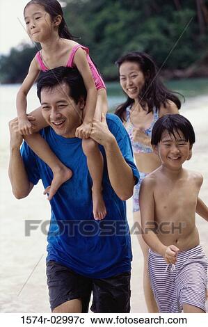 Stock Image - Parents with their son and daughter on the beach. Fotosearch
