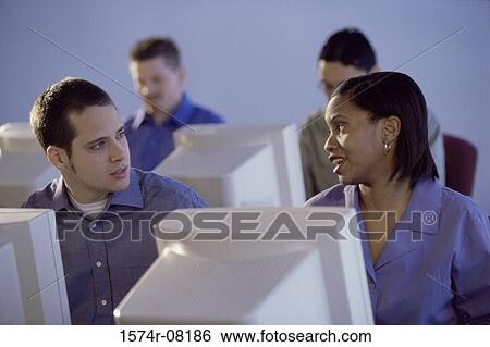 Stock Photograph - People sitting in front of computer monitors. Fotosearch