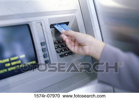 Stock Image - Person making an ATM transaction. Fotosearch