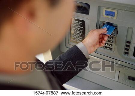 Stock Photo - Person making an ATM transaction. Fotosearch
