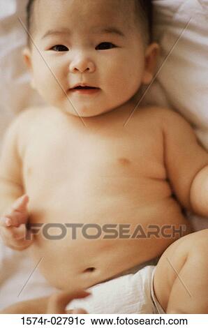 Portrait of a baby boy lying on a bed View Large Photo Image Stock Image - Portrait of a baby boy lying on a bed. Fotosearch