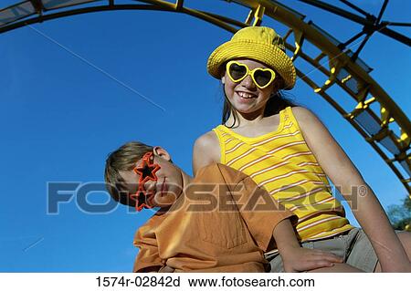 Stock Image - Portrait of a boy and a girl in an amusement park. Fotosearch