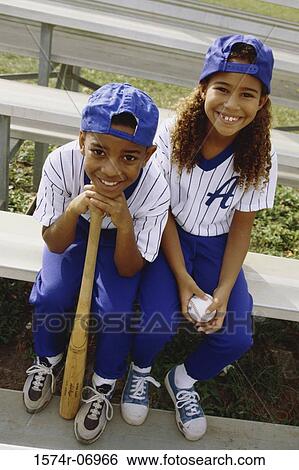 Stock Photograph - Portrait of a boy and a girl in baseball uniforms. Fotosearch