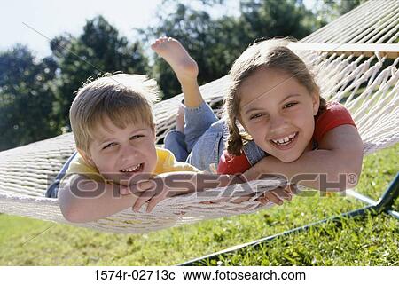 Portrait of a boy and a girl lying on a hammock View Large Photo Image Stock Image - Portrait of a boy and a girl lying on a hammock. Fotosearch