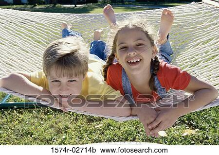 Portrait of a boy and a girl lying on a hammock View Large Photo Image Stock Image - Portrait of a boy and a girl lying on a hammock. Fotosearch