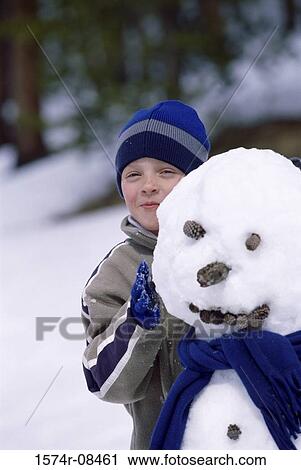 Portrait of a boy standing behind a snowman View Large Photo Image Stock Image - Portrait of a boy standing behind a snowman. Fotosearch