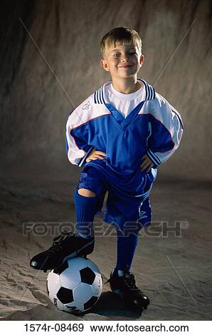 Portrait of a boy standing with his foot on a soccer ball View Large Photo Image Stock Photo - Portrait of a boy standing with his foot on a soccer ball. Fotosearch