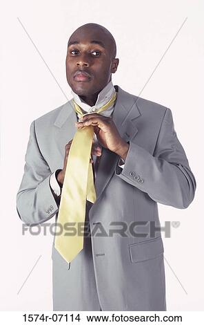 Portrait of a businessman adjusting his tie View Large Photo Image Picture - Portrait of a businessman adjusting his tie. Fotosearch