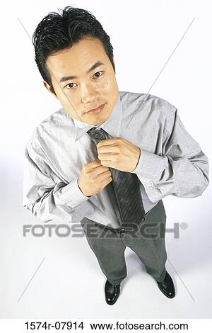 Portrait of a businessman adjusting his tie View Large Photo Image Picture - Portrait of a businessman adjusting his tie. Fotosearch