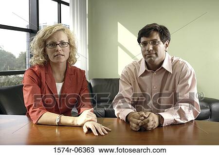 Stock Image - Portrait of a businessman and a businesswoman in an office. Fotosearch