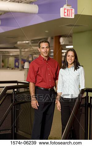 Portrait of a businessman and a businesswoman standing on stairs View Large Photo Image Stock Photo - Portrait of a businessman and a businesswoman standing on stairs. Fotosearch