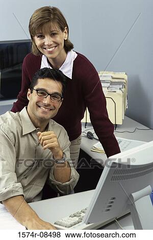 Stock Photo - Portrait of a businessman and a businesswoman in an office. Fotosearch