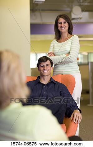 Portrait of a businessman and a businesswoman smiling in an office View Large Photo Image Stock Photography - Portrait of a businessman and a businesswoman smiling in an office. Fotosearch