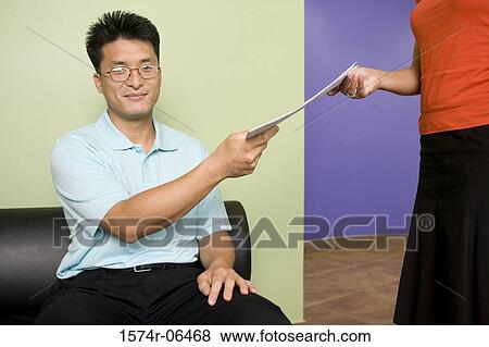 Portrait of a businessman giving a document to a businesswoman View Large Photo Image Stock Photo - Portrait of a businessman giving a document to a businesswoman. Fotosearch
