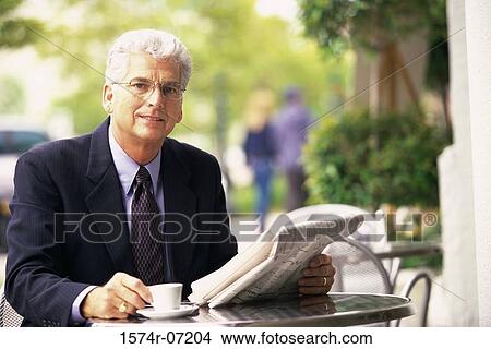 Portrait of a businessman holding a newspaper and a cup of coffee View Large Photo Image Picture - Portrait of a businessman holding a newspaper and a cup of coffee. Fotosearch