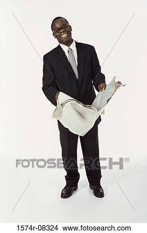 Picture - Portrait of a businessman holding a newspaper smiling. Fotosearch