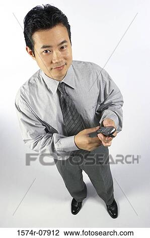 Portrait of a businessman holding a mobile phone View Large Photo Image Stock Image - Portrait of a businessman holding a mobile phone. Fotosearch