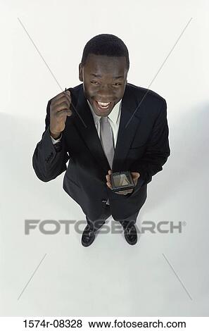 Stock Photo - Portrait of a businessman holding a hand held device. Fotosearch