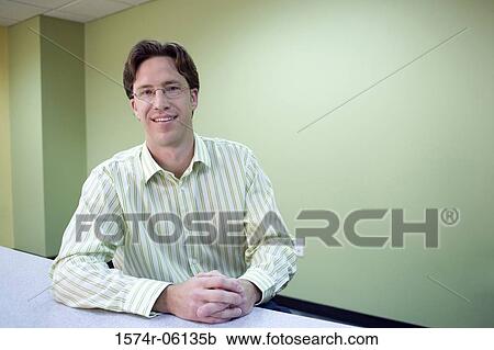 Portrait of a businessman sitting in an office View Large Photo Image Stock Image - Portrait of a businessman sitting in an office. Fotosearch