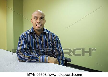 Stock Photo - Portrait of a businessman sitting in an office. Fotosearch