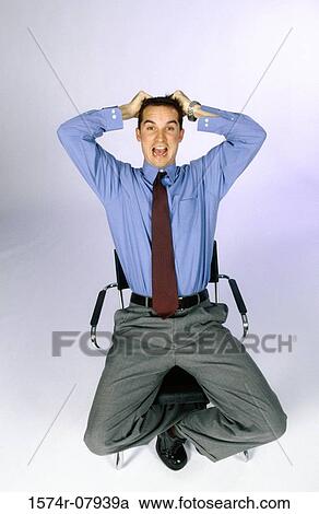 Stock Image - Portrait of a businessman sitting on a chair. Fotosearch