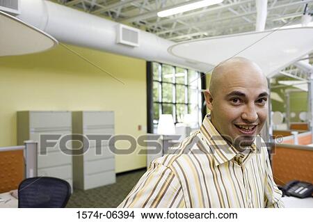 Portrait of a businessman smiling in an office View Large Photo Image Picture - Portrait of a businessman smiling in an office. Fotosearch