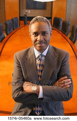Portrait of a businessman standing in a conference room smiling View Large Photo Image Stock Image - Portrait of a businessman standing in a conference room smiling. Fotosearch