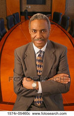 Portrait of a businessman standing in a conference room smiling View Large Photo Image Stock Image - Portrait of a businessman standing in a conference room smiling. Fotosearch