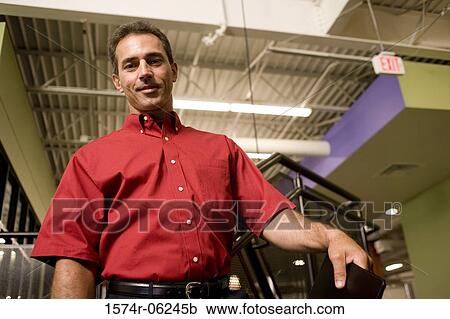 Stock Image - Portrait of a businessman standing in an office. Fotosearch
