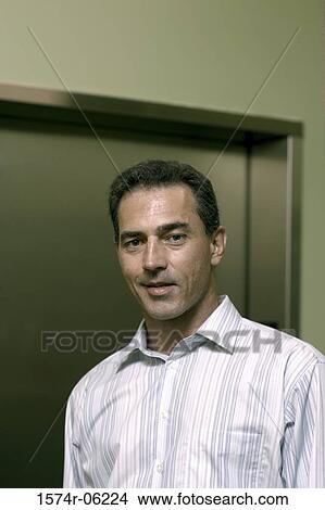 Picture - Portrait of a businessman standing near an elevator. Fotosearch