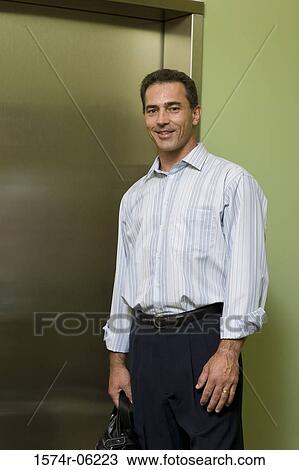 Portrait of a businessman standing near an elevator View Large Photo Image Stock Image - Portrait of a businessman standing near an elevator. Fotosearch