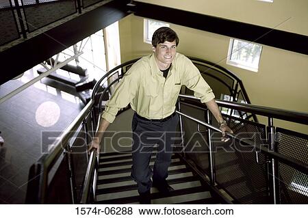 Portrait of a businessman standing on a staircase View Large Photo Image Stock Photo - Portrait of a businessman standing on a staircase. Fotosearch
