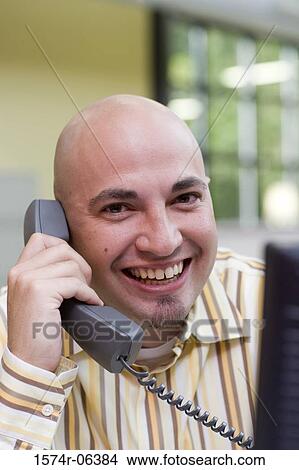 Portrait of a businessman talking on a telephone in an office View Large Photo Image Picture - Portrait of a businessman talking on a telephone in an office. Fotosearch