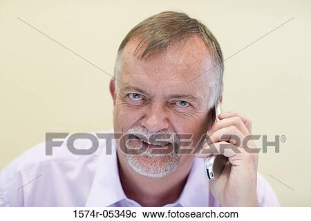 Portrait of a businessman talking on a mobile phone in an office View Large Photo Image Stock Image - Portrait of a businessman talking on a mobile phone in an office. Fotosearch
