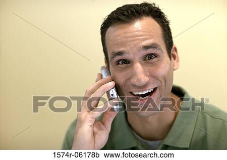 Stock Image - Portrait of a businessman talking on a mobile phone in an office. Fotosearch