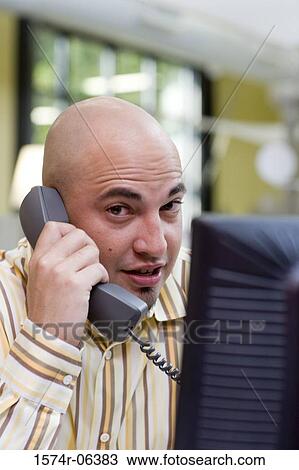 Portrait of a businessman talking on a telephone in an office View Large Photo Image Stock Image - Portrait of a businessman talking on a telephone in an office. Fotosearch