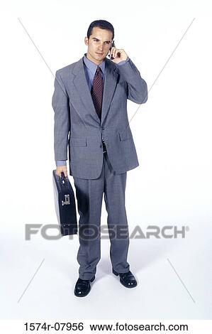 Portrait of a businessman talking on a mobile phone holding a briefcase View Large Photo Image Stock Photograph - Portrait of a businessman talking on a mobile phone holding a briefcase. Fotosearch