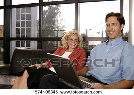 Portrait of a businessman using a laptop with a businesswoman sitting beside him View Large Photo Image Stock Photography - Portrait of a businessman using a laptop with a businesswoman sitting beside him. Fotosearch
