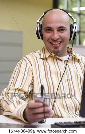 Portrait of a businessman wearing headphones in an office View Large Photo Image Stock Image - Portrait of a businessman wearing headphones in an office. Fotosearch