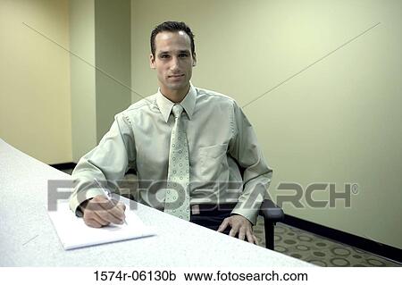 Portrait of a businessman writing on a notepad in an office View Large Photo Image Stock Image - Portrait of a businessman writing on a notepad in an office. Fotosearch