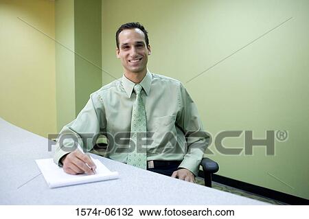 Portrait of a businessman writing on a notepad in an office View Large Photo Image Stock Image - Portrait of a businessman writing on a notepad in an office. Fotosearch